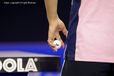 A generic cropped image of the hand of a table tennis player holding the ball and about to serve.