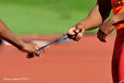 A cropped generic image of the hands of a blind runner and his guide and the strap that holds them together during the Athletics competition of the London 2102 Paralympic Games.