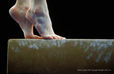 A generic image of the feet of a gymnast poised on the end of the Balance Beam during her competitive routine.